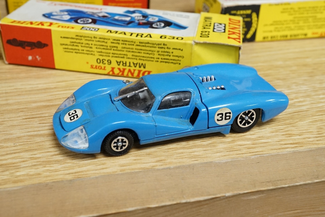 Four boxed Dinky Toys cars; a Triumph Spitfire (114) in red with cream interior, together with three Speedwheels; a Matra 630 (200) in blue, a Ferrari 312P (204) in metallic red, and a McLaren M8A Can Am (223) in white a